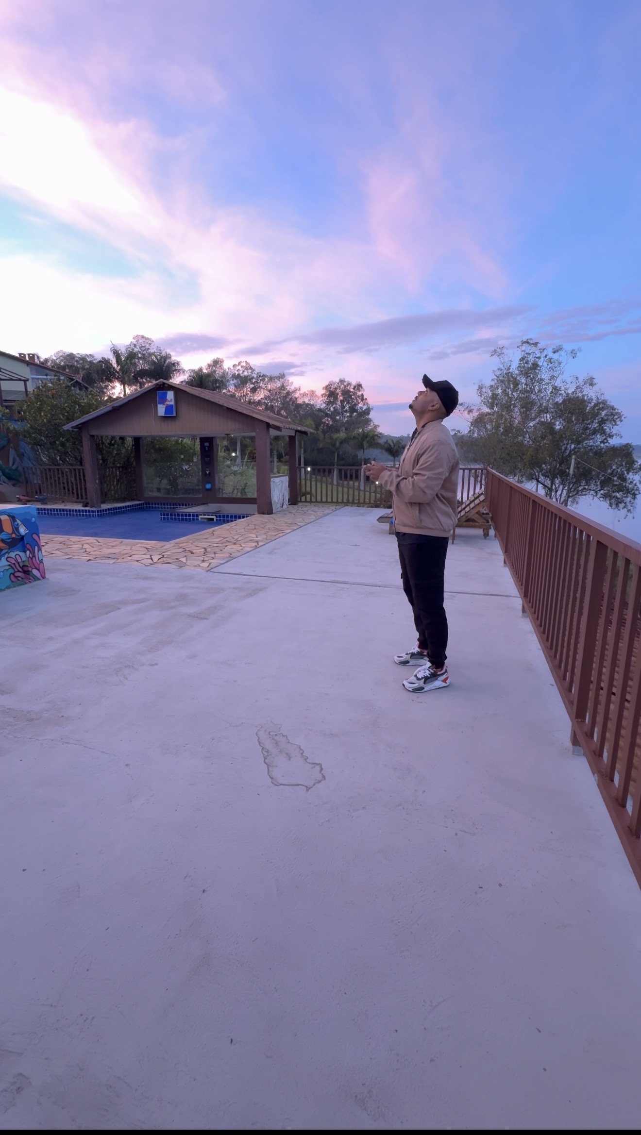 Thiago operando o controle do drone ao entardecer