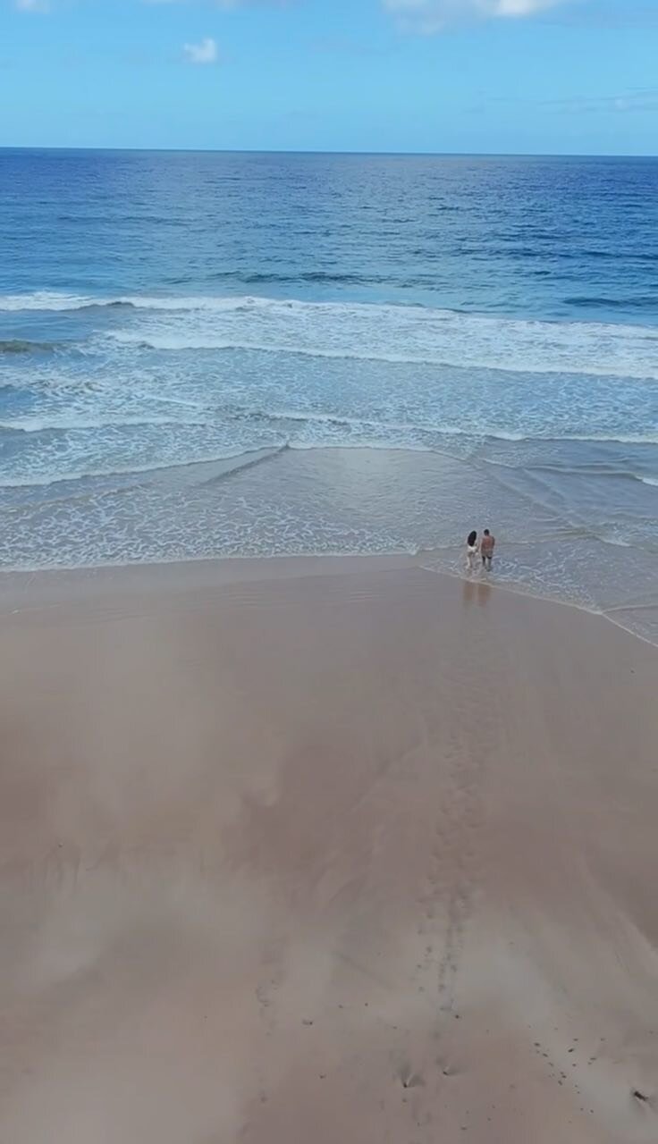 Casal caminhando na praia — vista aérea